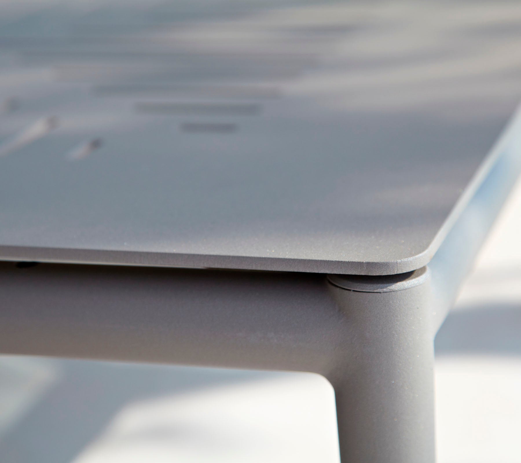 Acercamiento de una mesa moderna y elegante con una superficie suave y detalles sutiles. El diseño enfatiza líneas limpias y un estilo minimalista.