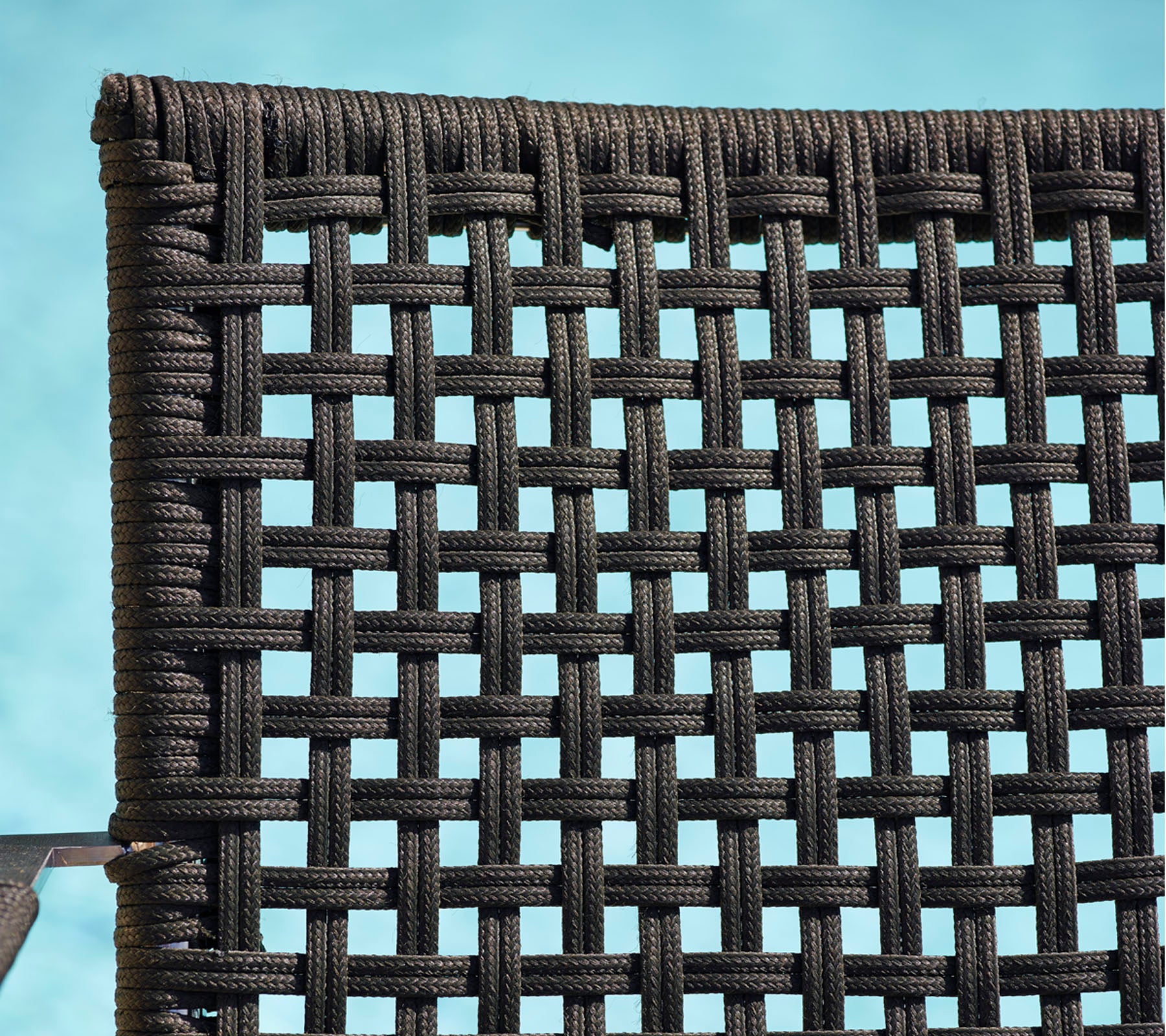 Primer plano detallado de un material negro tejido, que muestra un patrón texturizado adecuado para muebles o decoración.