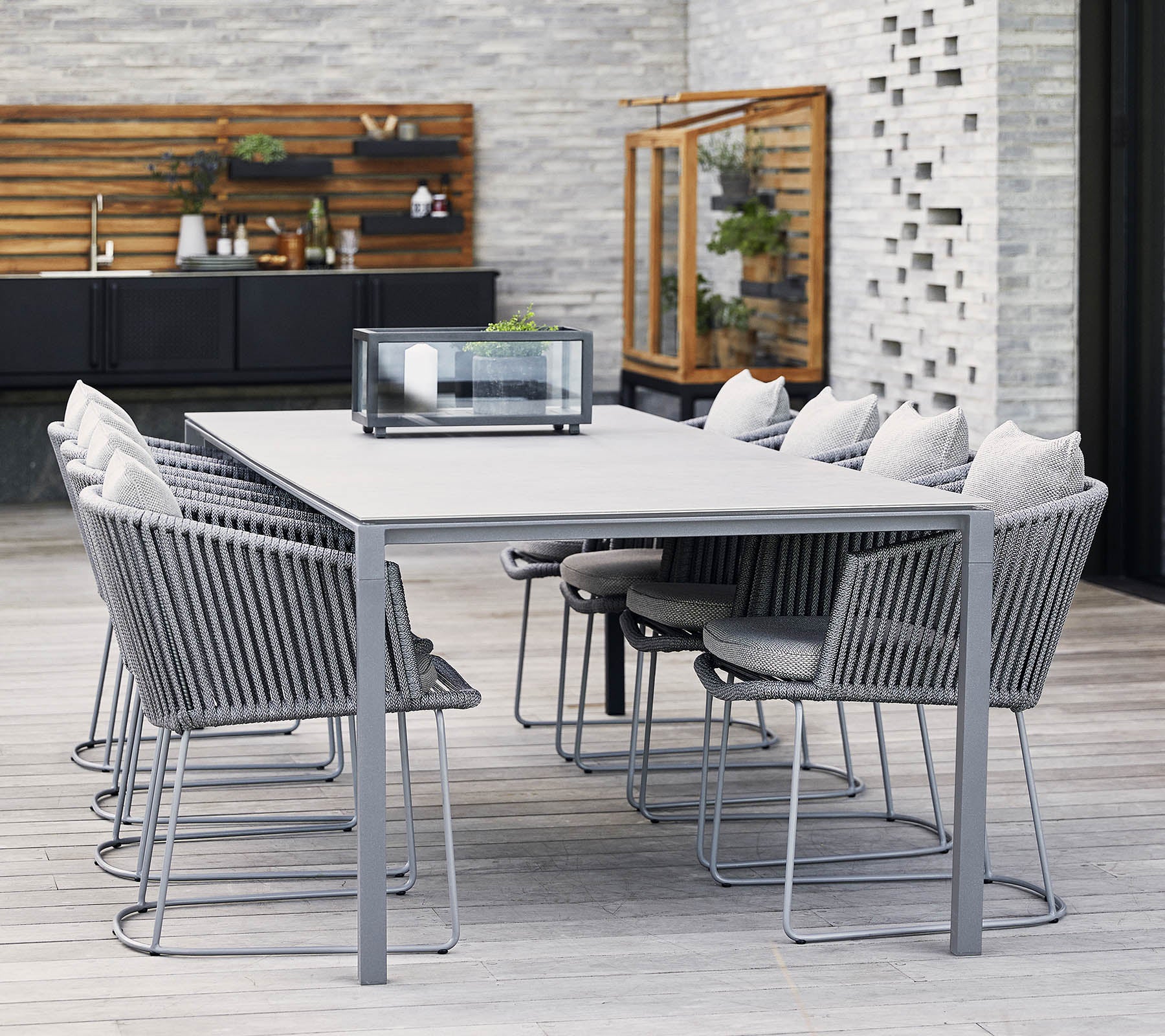 Una mesa de comedor moderna con marco de metal gris y sillas cómodas, con cojines suaves y un diseño minimalista, perfecta para reuniones.