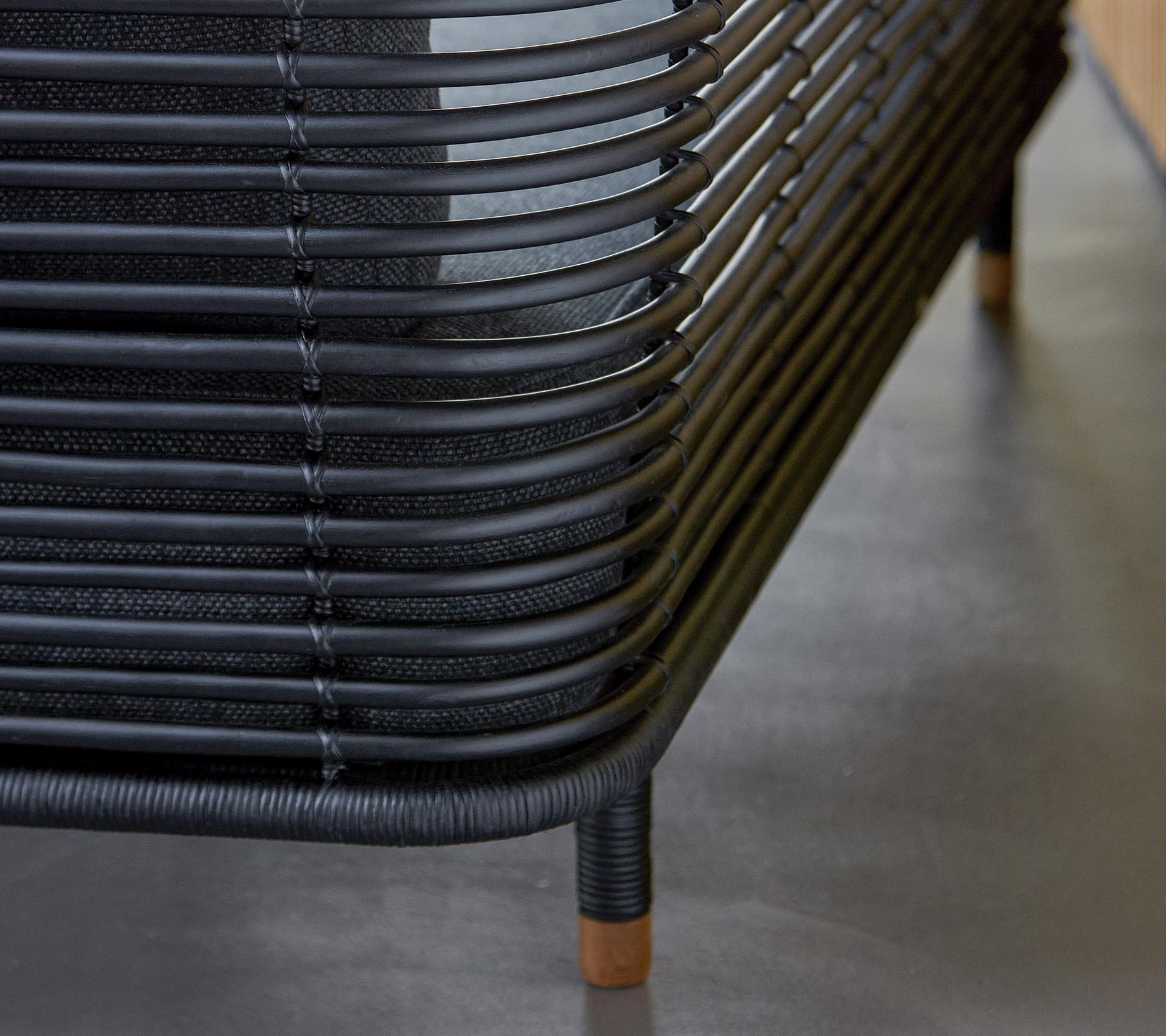 Muebles tejidos negros y elegantes con líneas curvas y acentos de madera, que muestran una estética de diseño moderno. Un complemento perfecto para cualquier espacio.