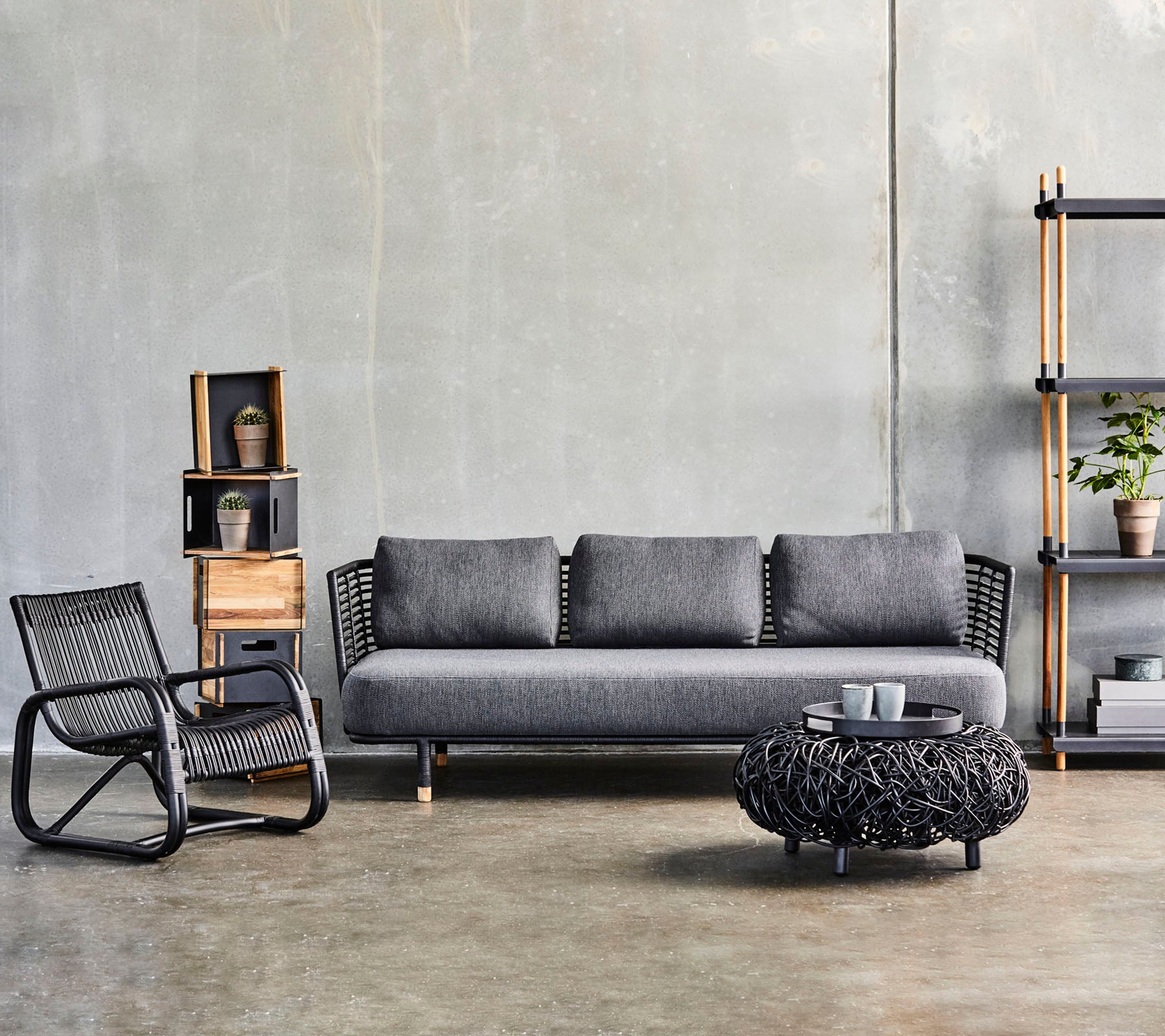 Configuración moderna de sala de estar con un sofá elegante, una mesa de café texturizada y una silla de acento estilizada, complementada por estanterías decorativas.