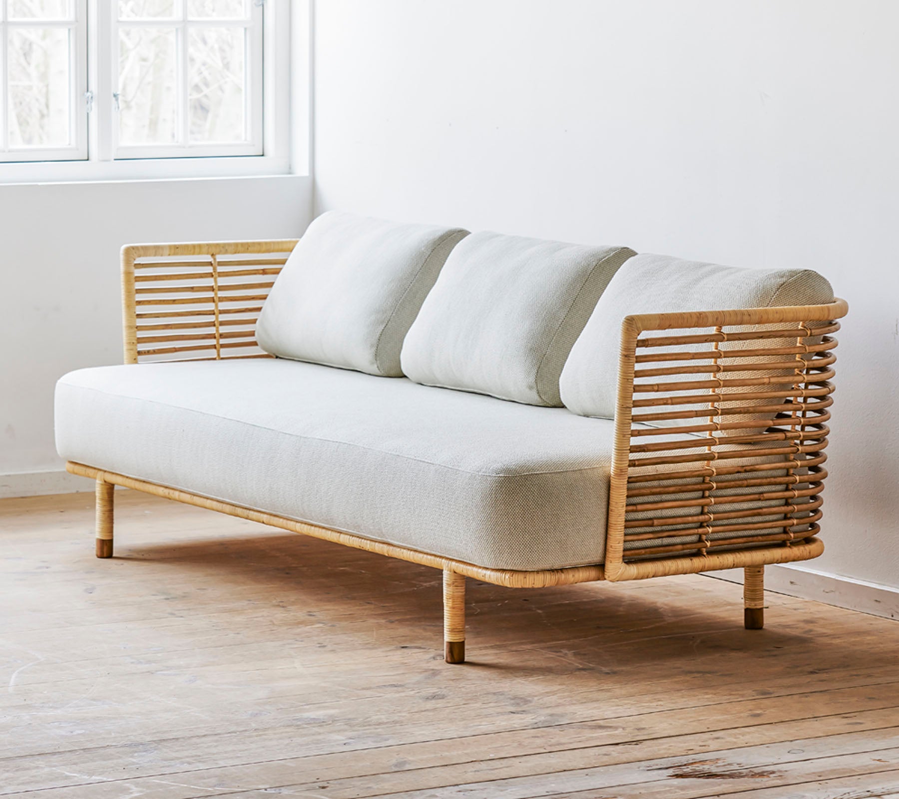 Un sofá moderno con un diseño elegante, con un asiento de tela clara y acentos de madera estilizados. Perfecto para espacios contemporáneos.