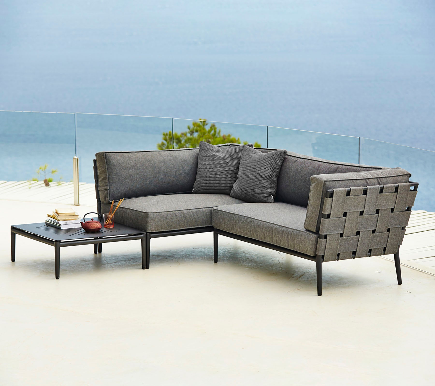 Sofá seccional exterior elegante con cómodos cojines y una mesa auxiliar a juego, perfecta para la relajación y el disfrute.
