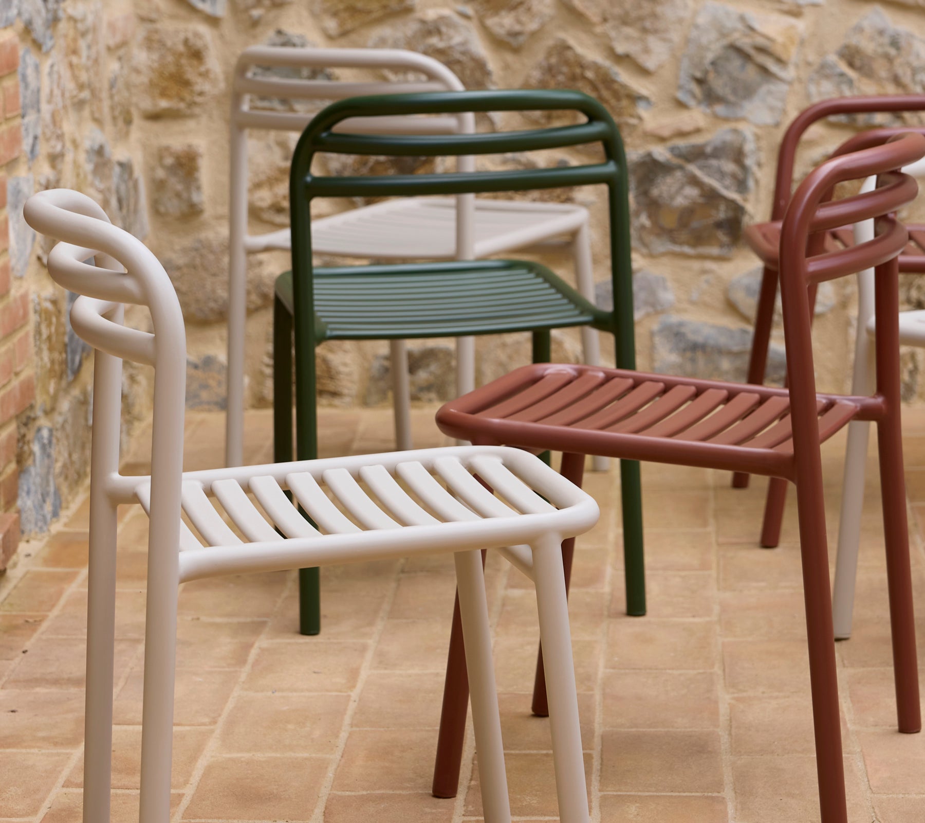 Sillas Bliss mostradas en varios colores, con un diseño moderno de asientos ranurados y brazos curvados.