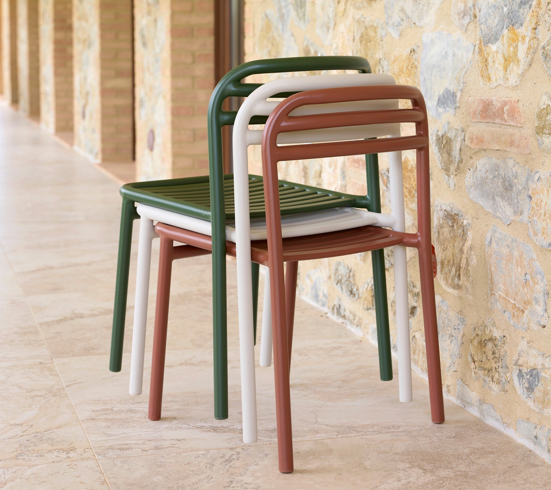 Una pila de sillas Bliss en varios colores, que muestra un diseño elegante y practicidad para un almacenamiento que ahorra espacio.