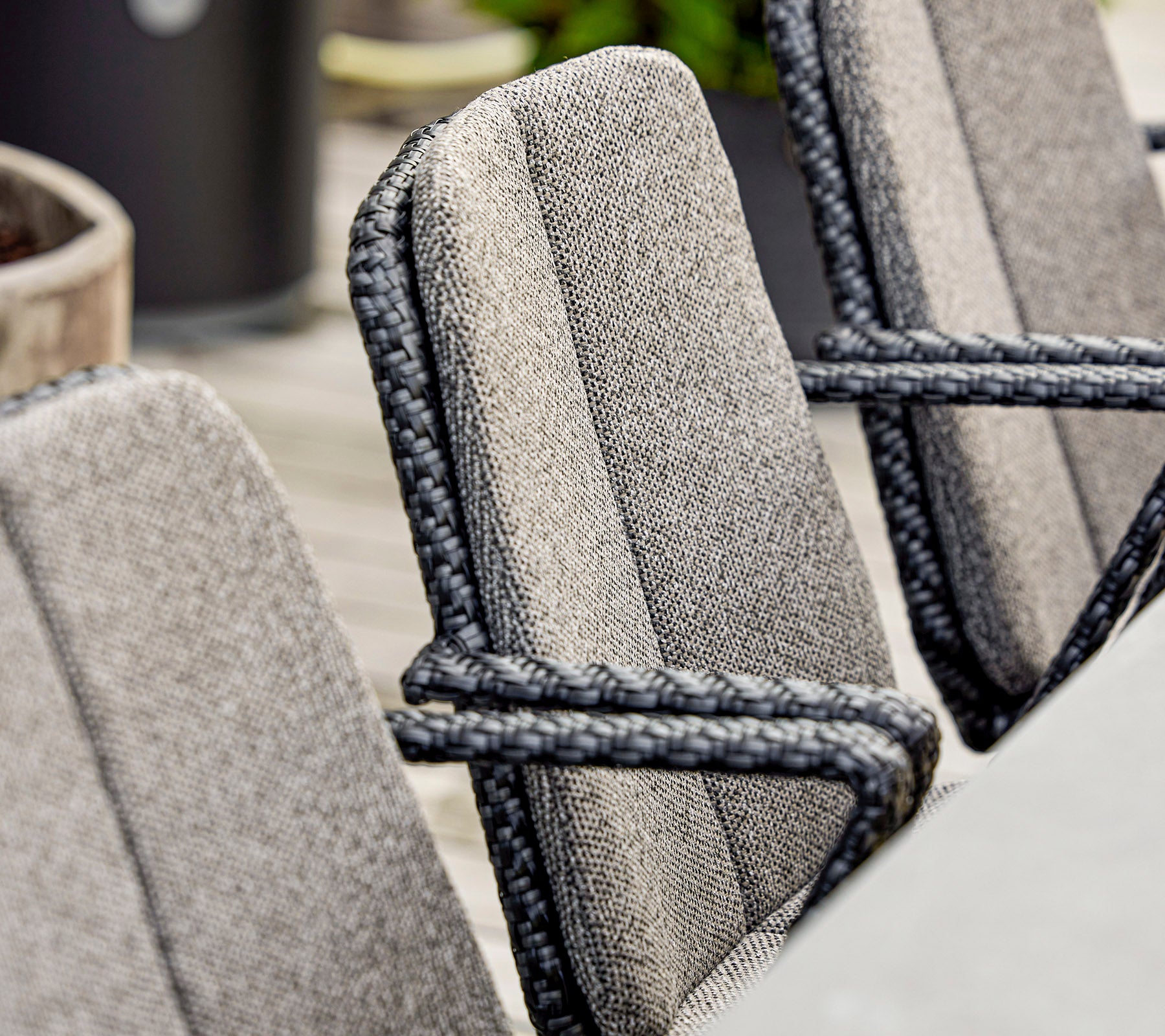 Primer plano de sillas elegantes con tela texturizada y detalles de cuerda elegante, adecuadas para asientos al aire libre modernos.