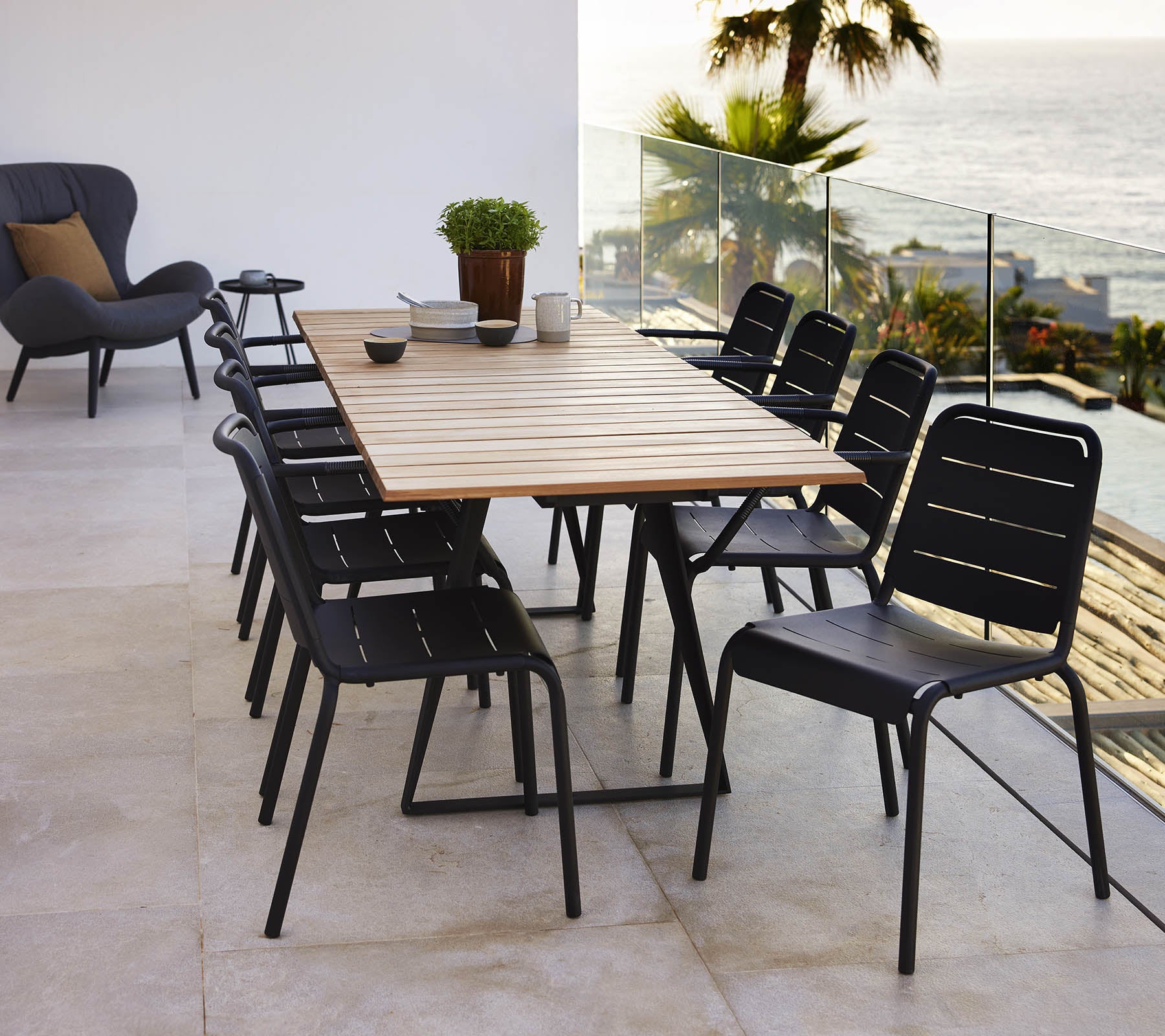Una mesa de Copenhague con una parte superior de madera rodeada de sillas negras de Copenhague, creando una configuración de comedor elegante.