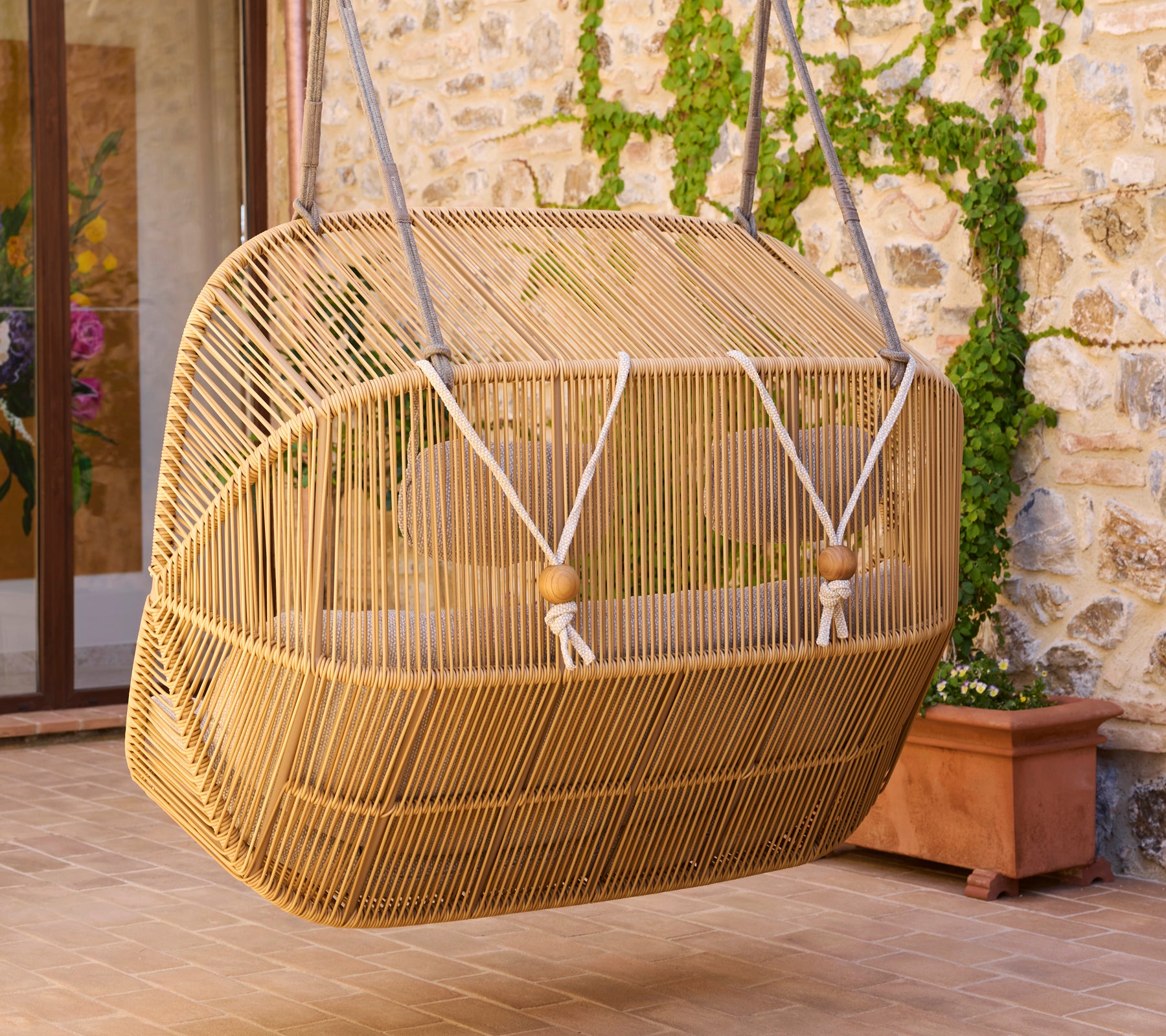Back view of a Hive sofa, featuring a unique woven design with a sturdy hanging mechanism and natural finish.