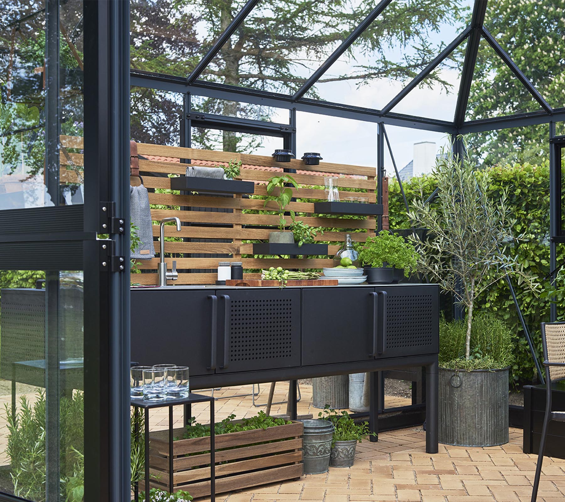Una unidad de almacenamiento moderna con plantas en estanterías de madera, rodeada de vegetación y dispuesta decorativamente con varias macetas.