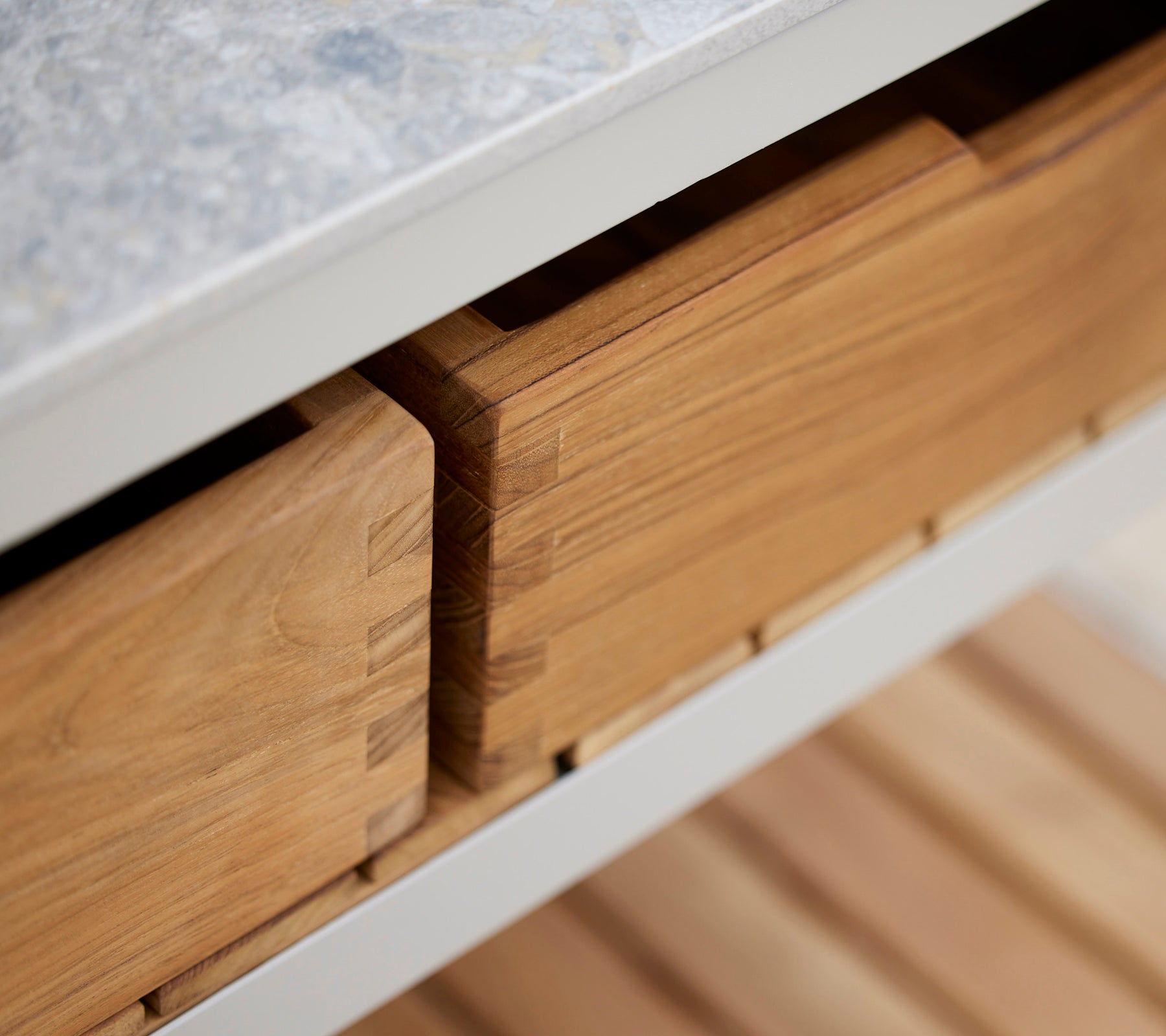 Cajas de teca con un acabado suave, ordenadamente guardadas y organizadas, mostrando la artesanía y la veta natural de la madera.