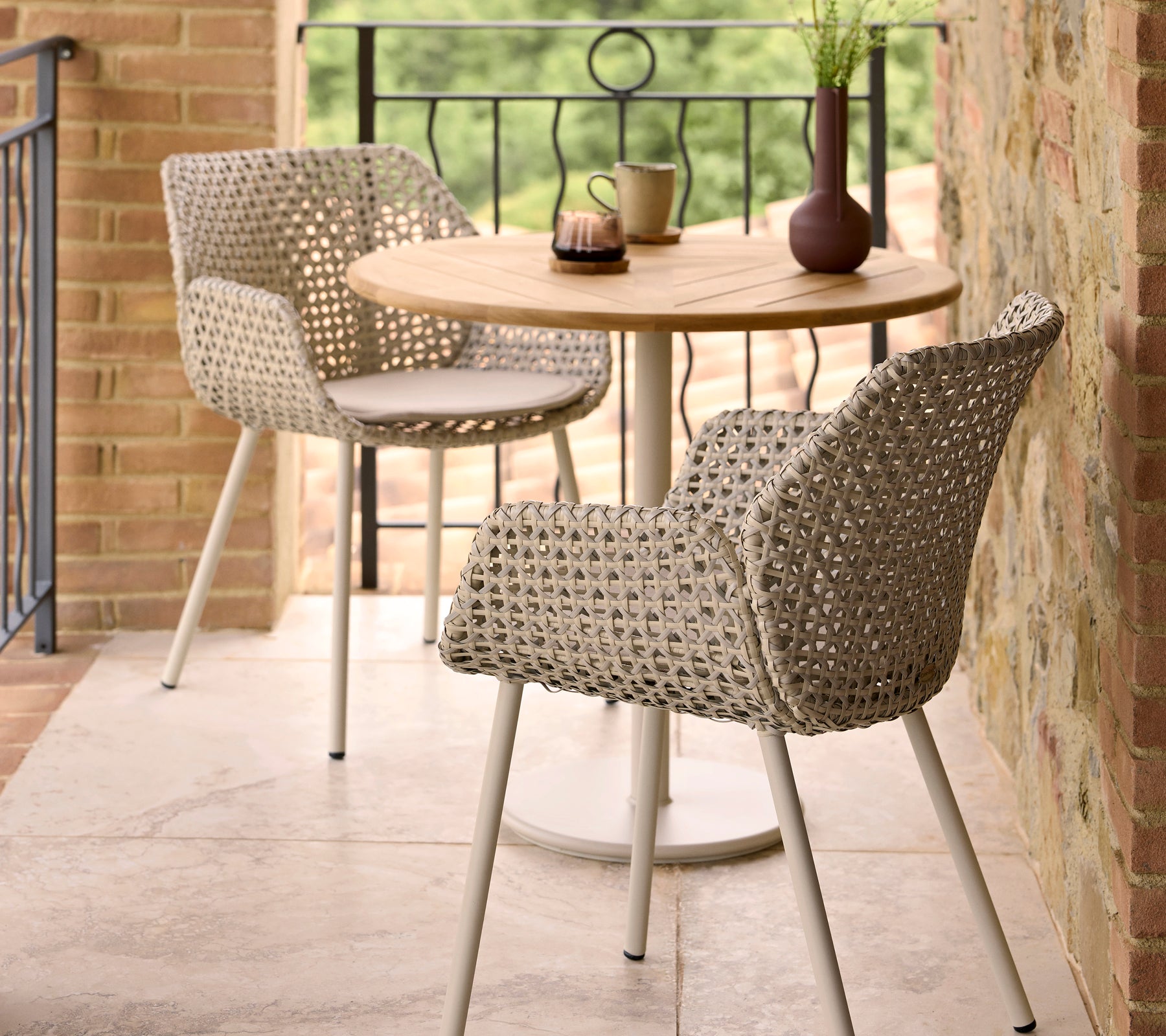 Sillas de comedor Vibe elegantes combinadas con una mesa redonda Go café, complementadas con elementos decorativos en la mesa.