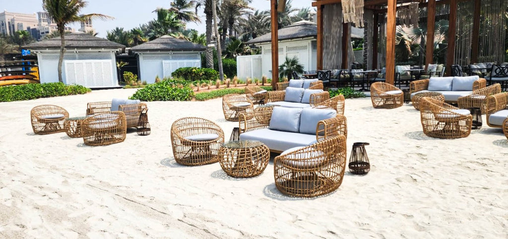 Lounge at the beach with Cane-line Nest series consisting 2-seater sofa, round lounge chairs and coffee table