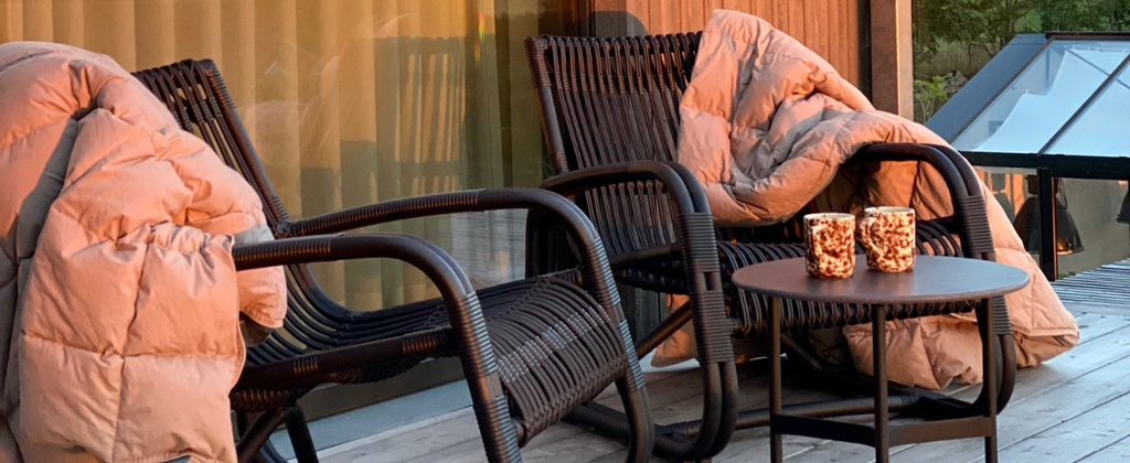 Outdoor sunset with two black Curve lounge chairs with comfy rosa duvets 