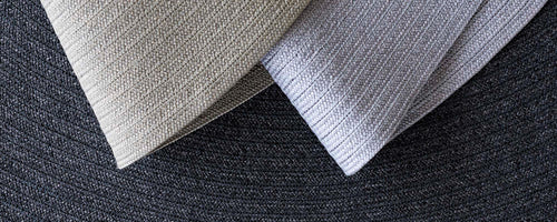 Dos muestras de alfombra texturizadas en colores claros, que muestran patrones contrastantes contra un fondo más oscuro.