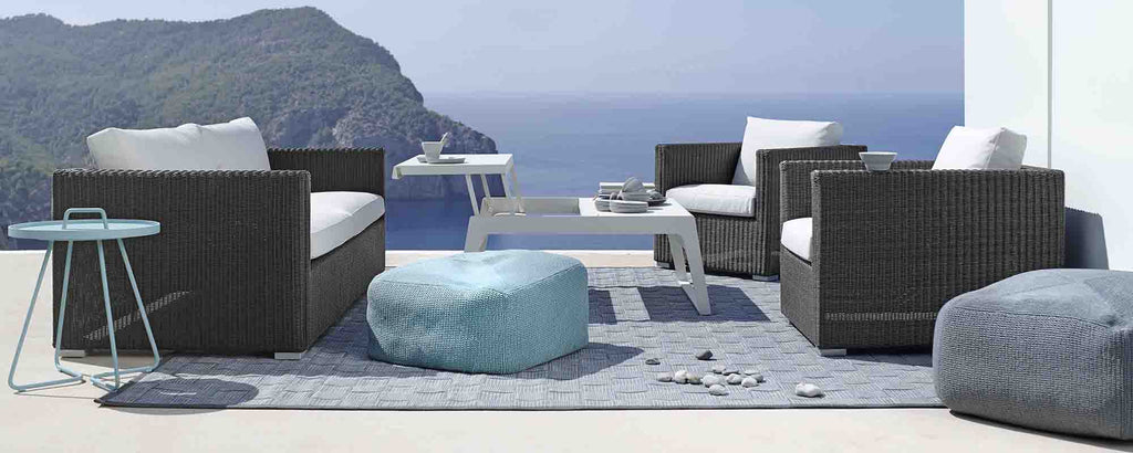 Stylish lounge seating in graphite, featuring cushions, a table, and a cozy area rug, perfect for relaxation and entertaining.
