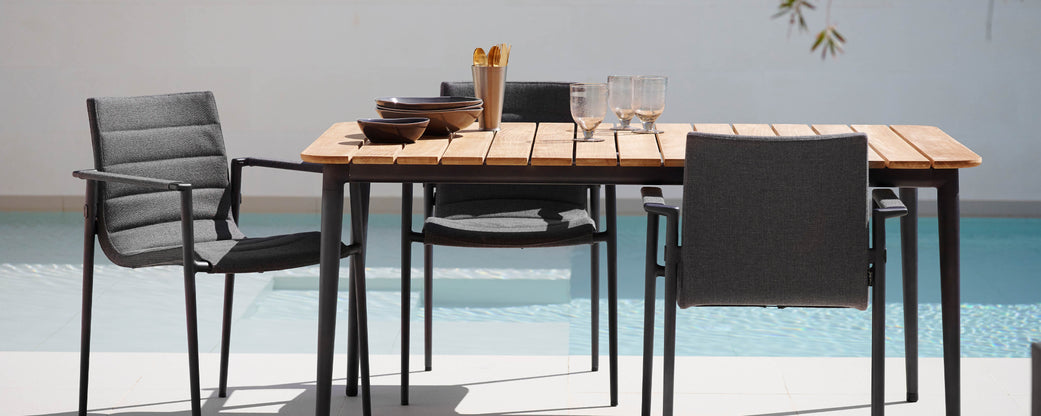 A stylish dining table with sleek black chairs, featuring a wooden top and decorative items, perfect for casual gatherings.