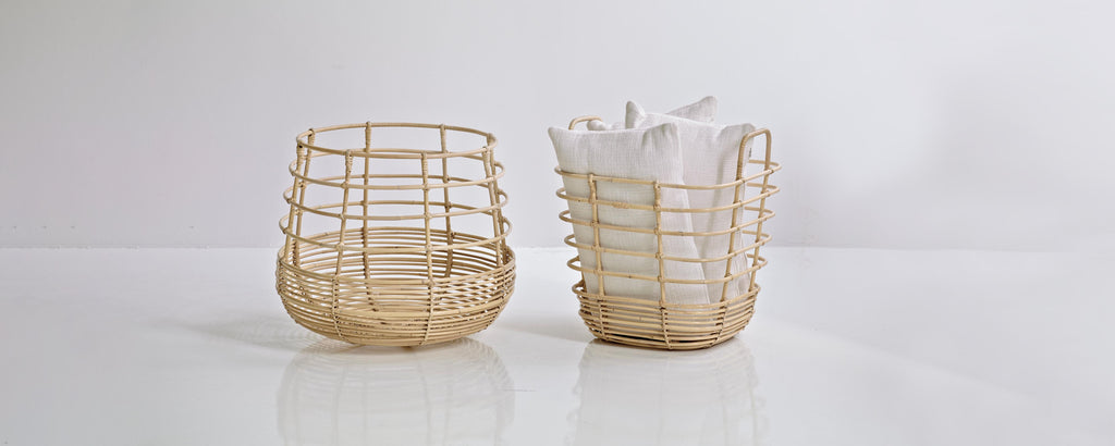 Two woven baskets made of natural material, one filled with folded white napkins, showcasing a minimalist and functional design.
