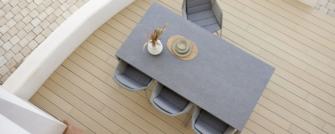 Modern outdoor dining setup featuring a gray table, stylish chairs, and a decorative centerpiece. Perfect for gatherings.
