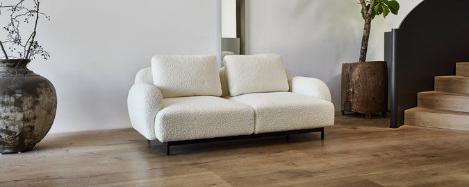 Sofá blanco moderno en un ambiente de salón contemporáneo.