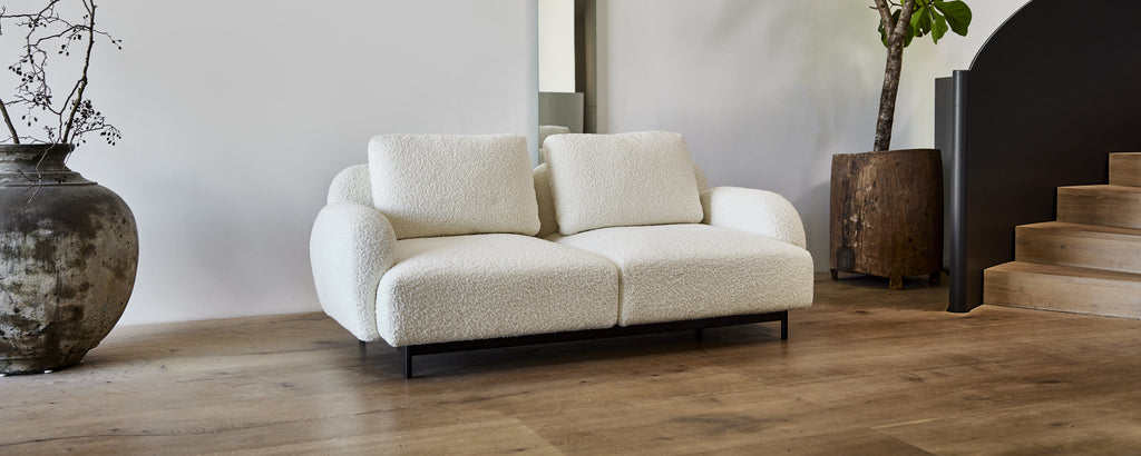 Sofá blanco moderno en un ambiente de salón contemporáneo.