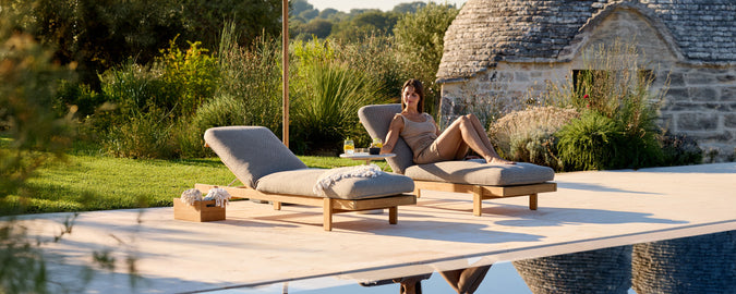 Sillas de lounge grises contemporáneas junto a una piscina en un ambiente al aire libre.