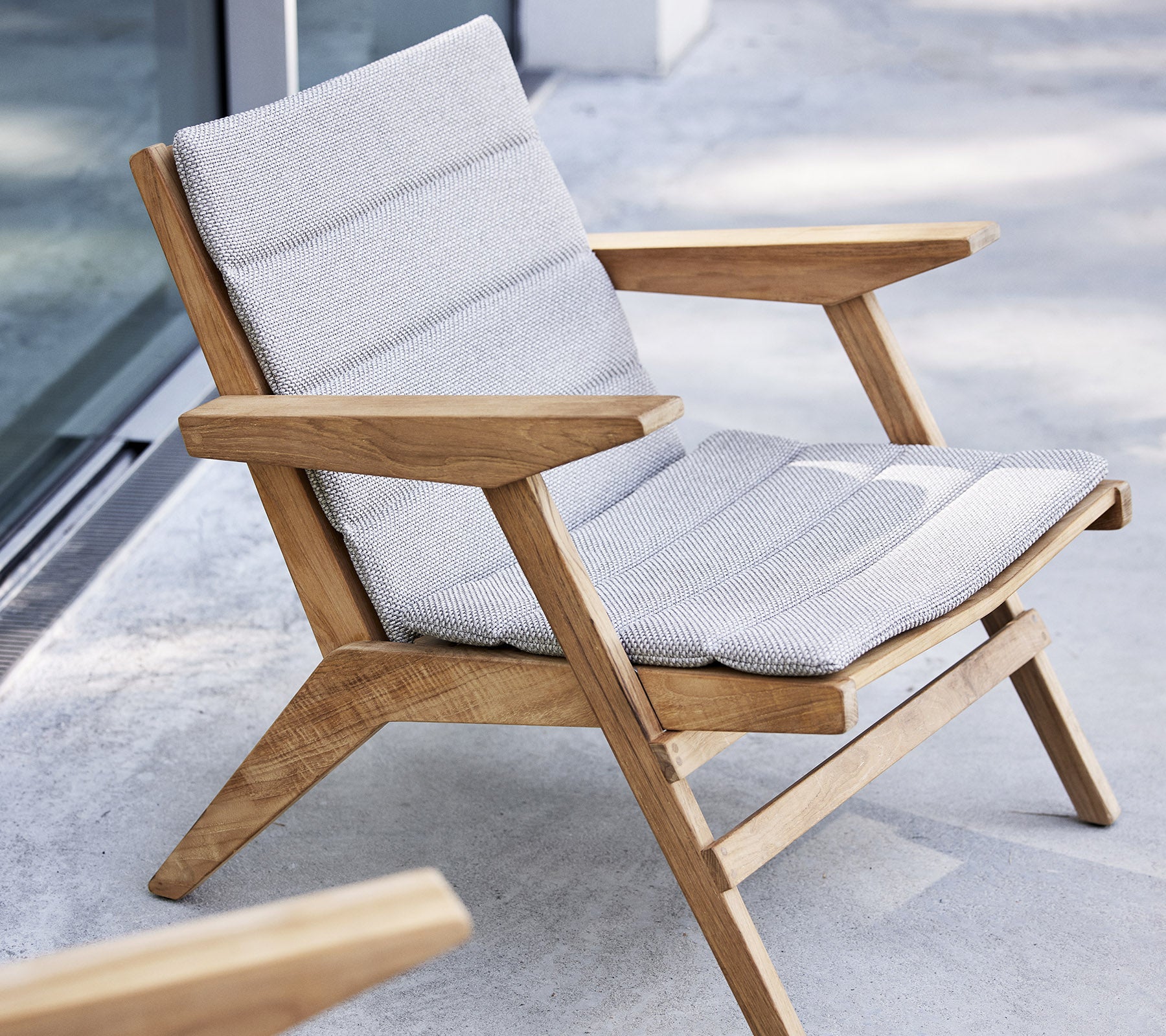 Sillón elegante con marco de madera y asiento acolchado, diseñado para la comodidad y la relajación.