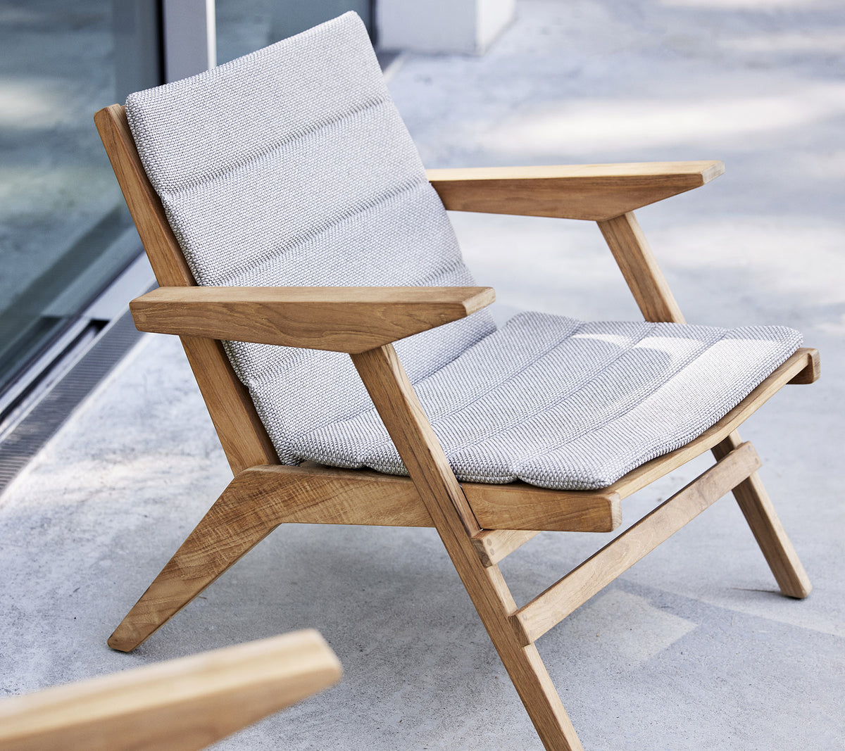 Sillón elegante con marco de madera y asiento acolchado, diseñado para la comodidad y la relajación.