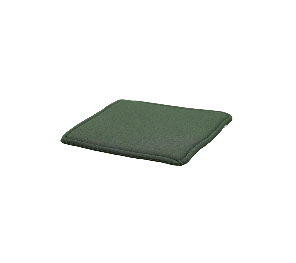 Cojín verde claro colocado sobre una superficie plana.