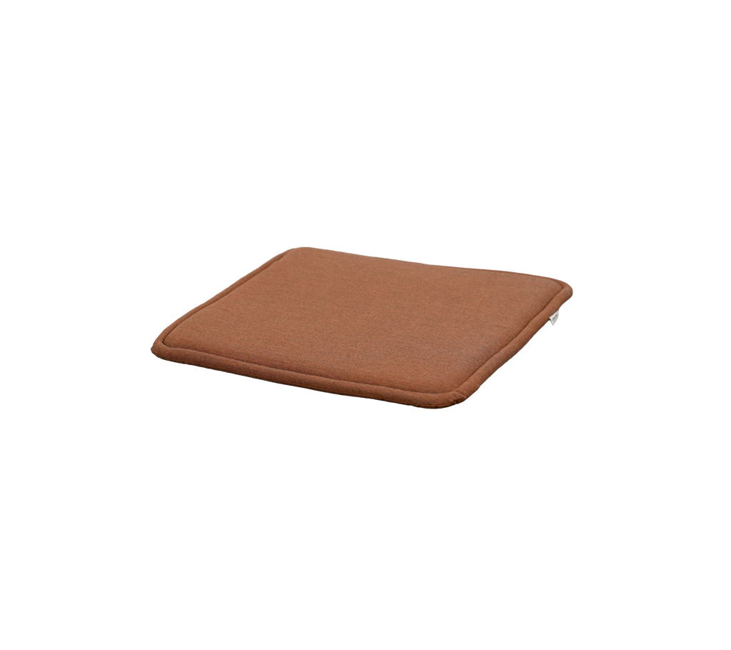 almohada roja desértica con forma cuadrada y grosor sutil.