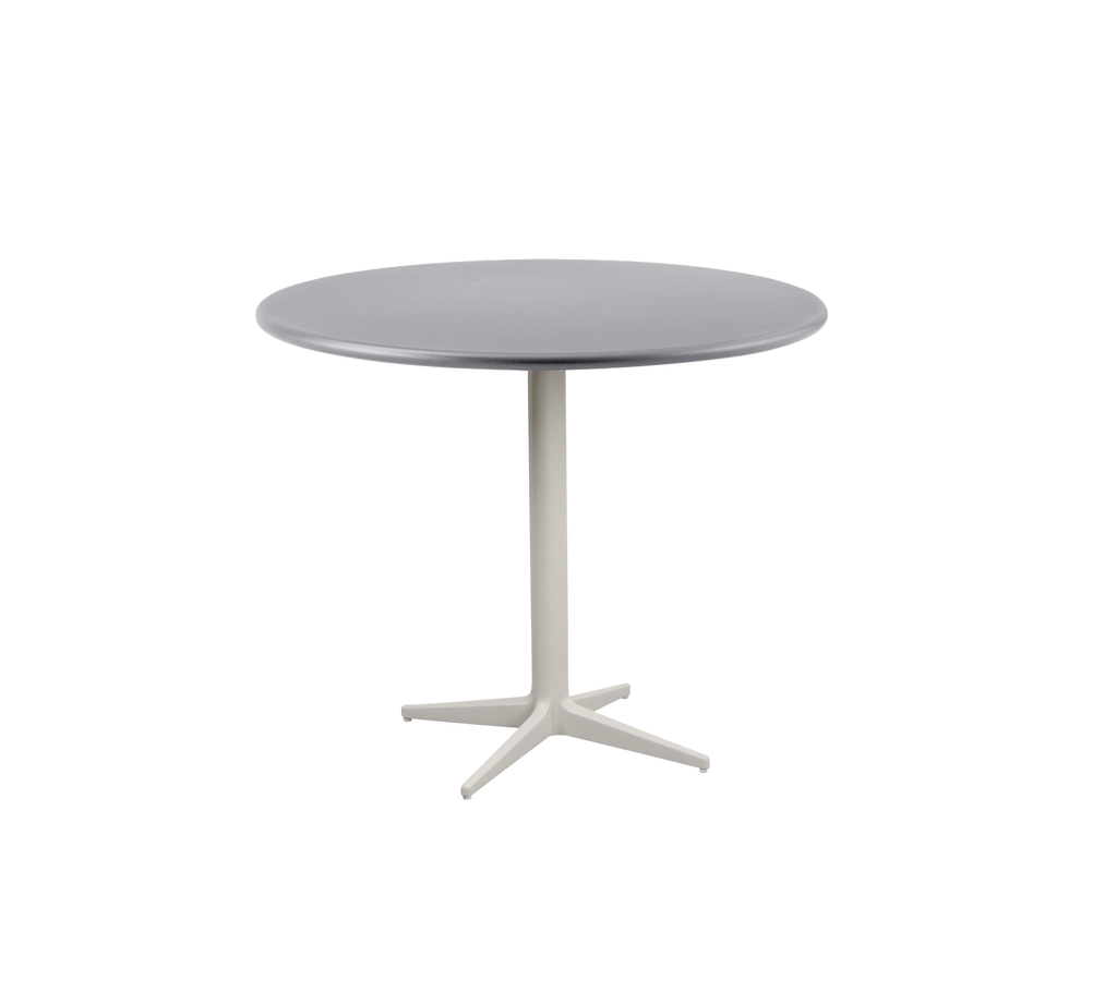 Mesa redonda moderna con una parte superior gris suave y una base robusta de color claro con un diseño de cuatro patas.