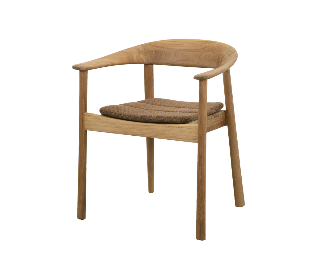 Silla de teca con cojín marrón umber en un ambiente de comedor moderno.