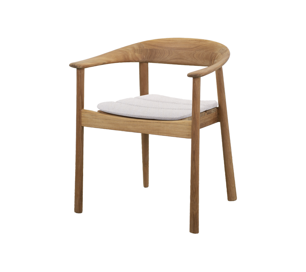 Silla de teca con cojín blanco en un ambiente moderno de salón.