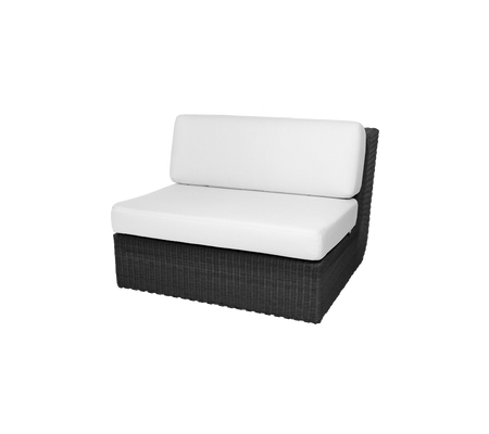 Sillón de mimbre negro con un cojín blanco, diseñado para la comodidad y el estilo en espacios de relajación.