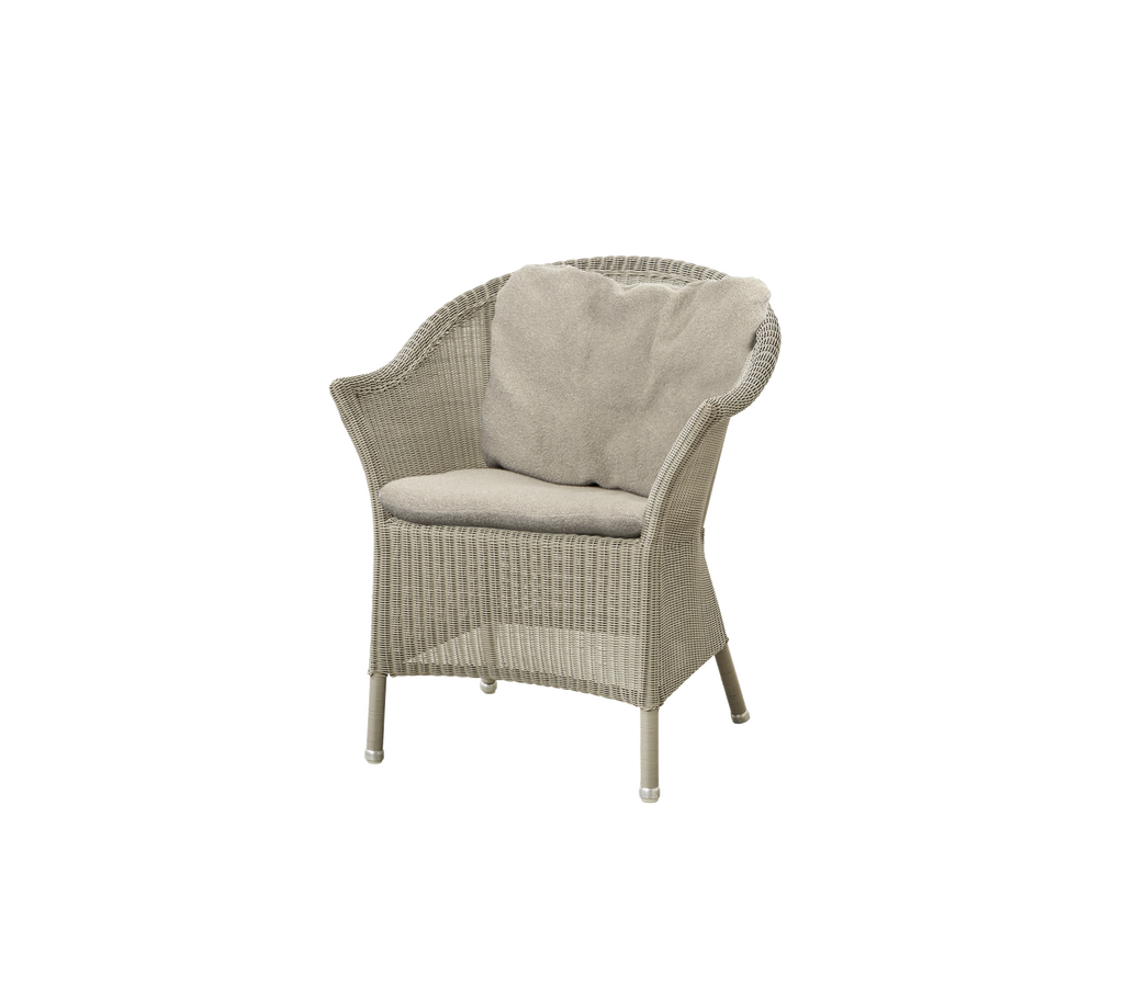 Silla tejida con un cojín de color claro, con un respaldo curvado y patas robustas, perfecta para relajarse.