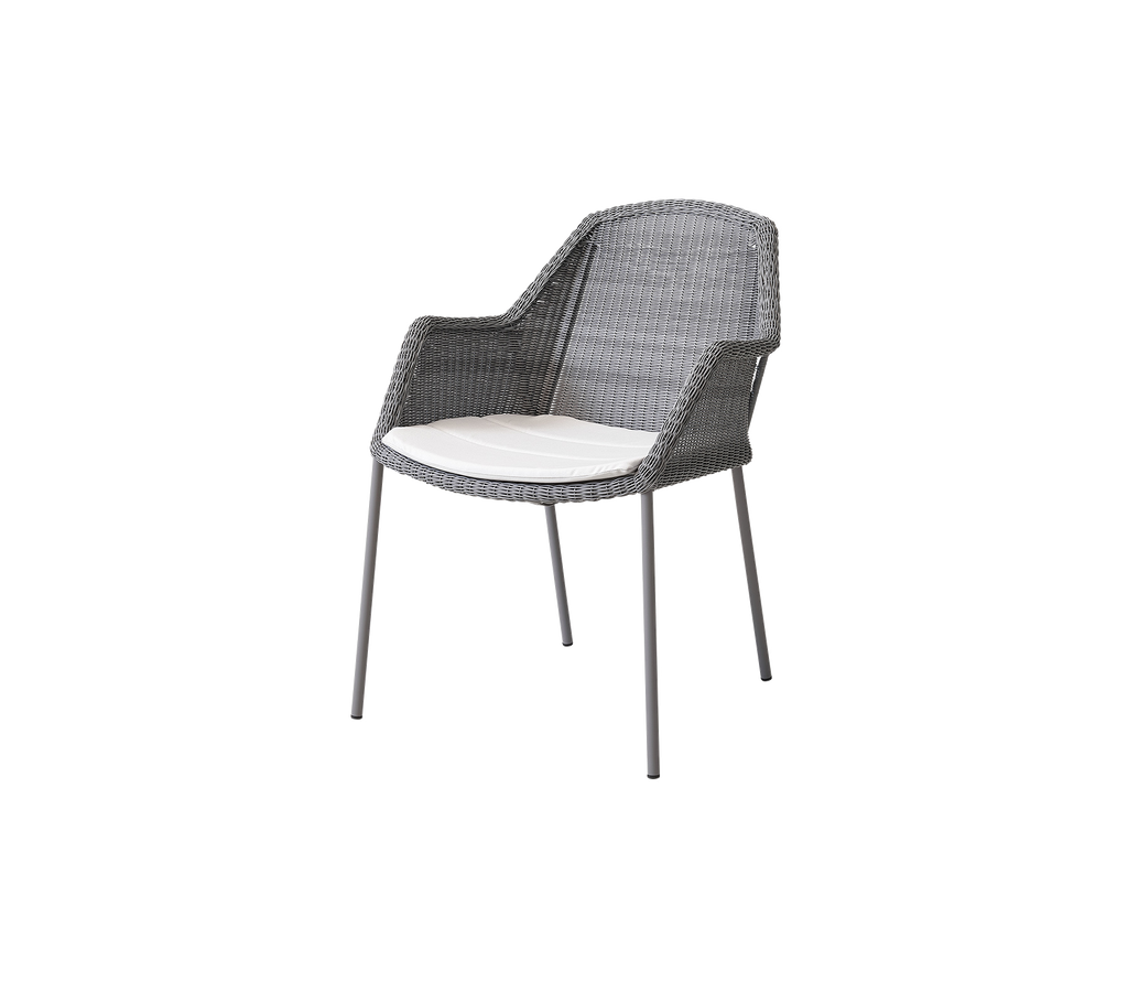 Silla gris estilosa con un diseño trenzado y un cojín ligero, perfecta para sentarse de manera relajada en diversos entornos.
