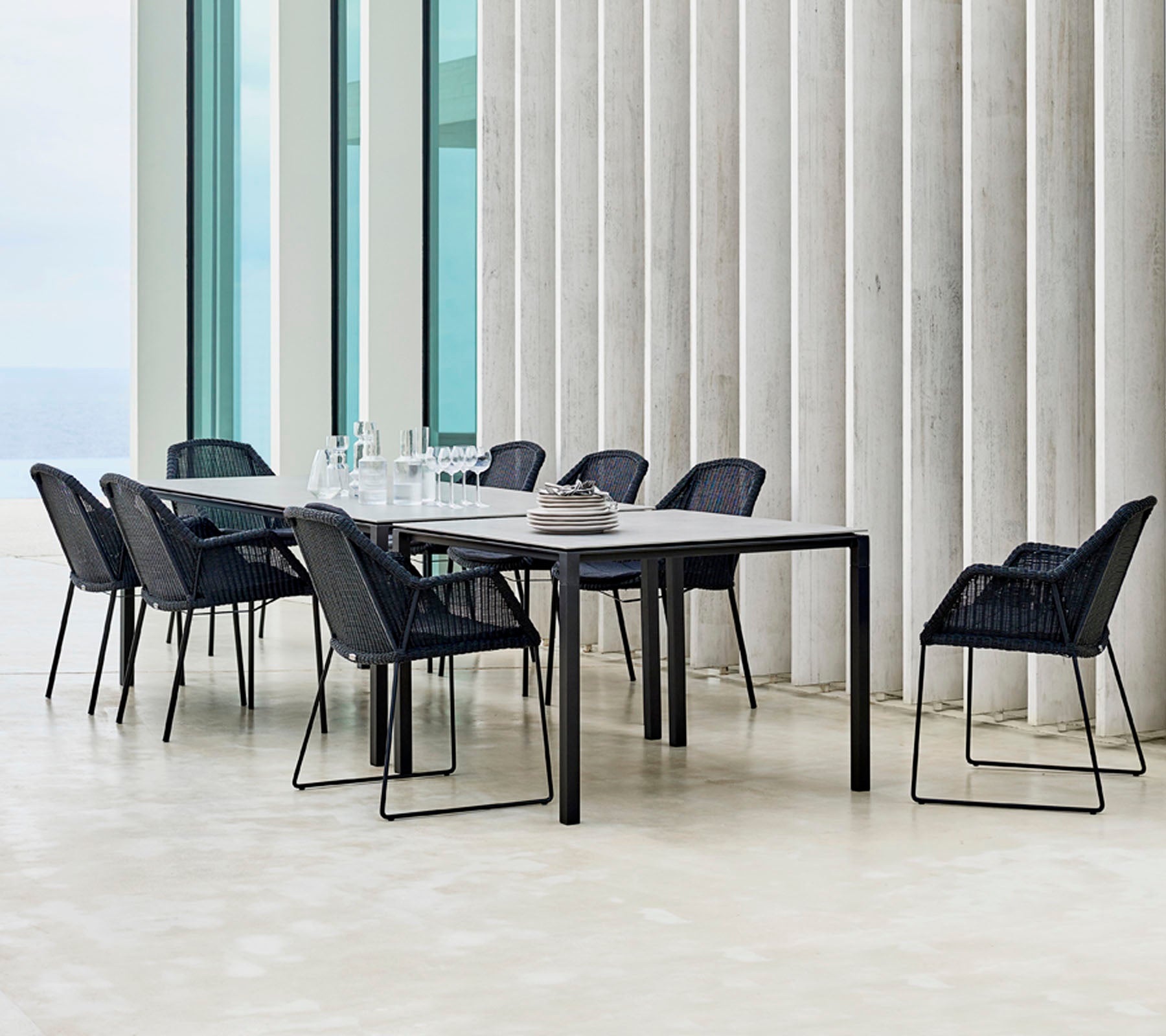 Un conjunto de mesa de comedor moderno con sillas negras dispuestas a su alrededor, con elementos de diseño minimalistas y una elegante presentación de mesa.