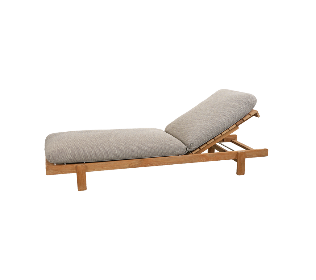 Sillón marrón claro con un cojín gris y respaldo ajustable.