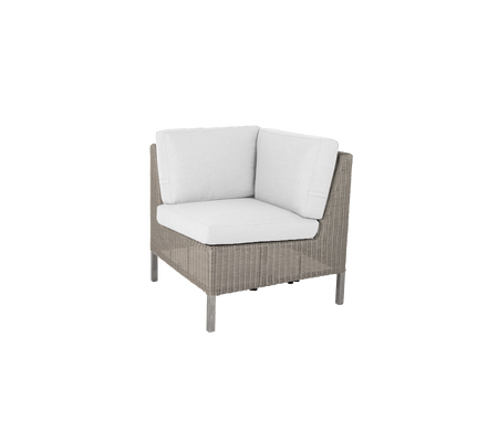 Silla de esquina con exterior tejido y almohadones blancos suaves, perfecta para añadir comodidad y estilo a cualquier espacio.