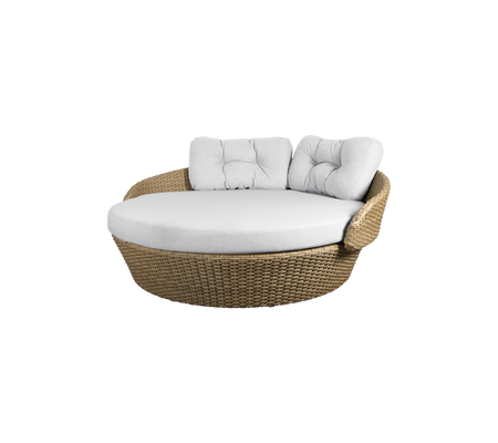 Silla de lounge de mimbre redonda con un cojín blanco suave y dos cojines de respaldo para mayor comodidad. Ideal para relajarse.