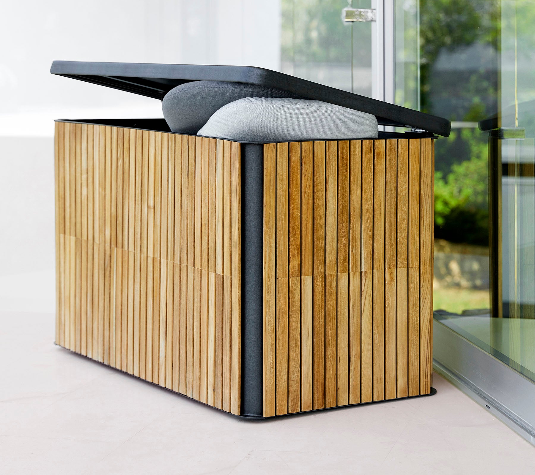 Caja de almacenamiento elegante con un exterior de madera con listones y una tapa con bisagra, que presenta una parte superior acolchada para mayor comodidad y funcionalidad.