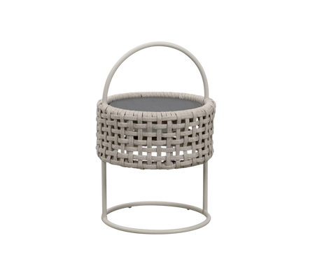 Cesta redonda de mimbre con asa, apoyada en un soporte de metal minimalista, perfecta para almacenamiento o uso decorativo.