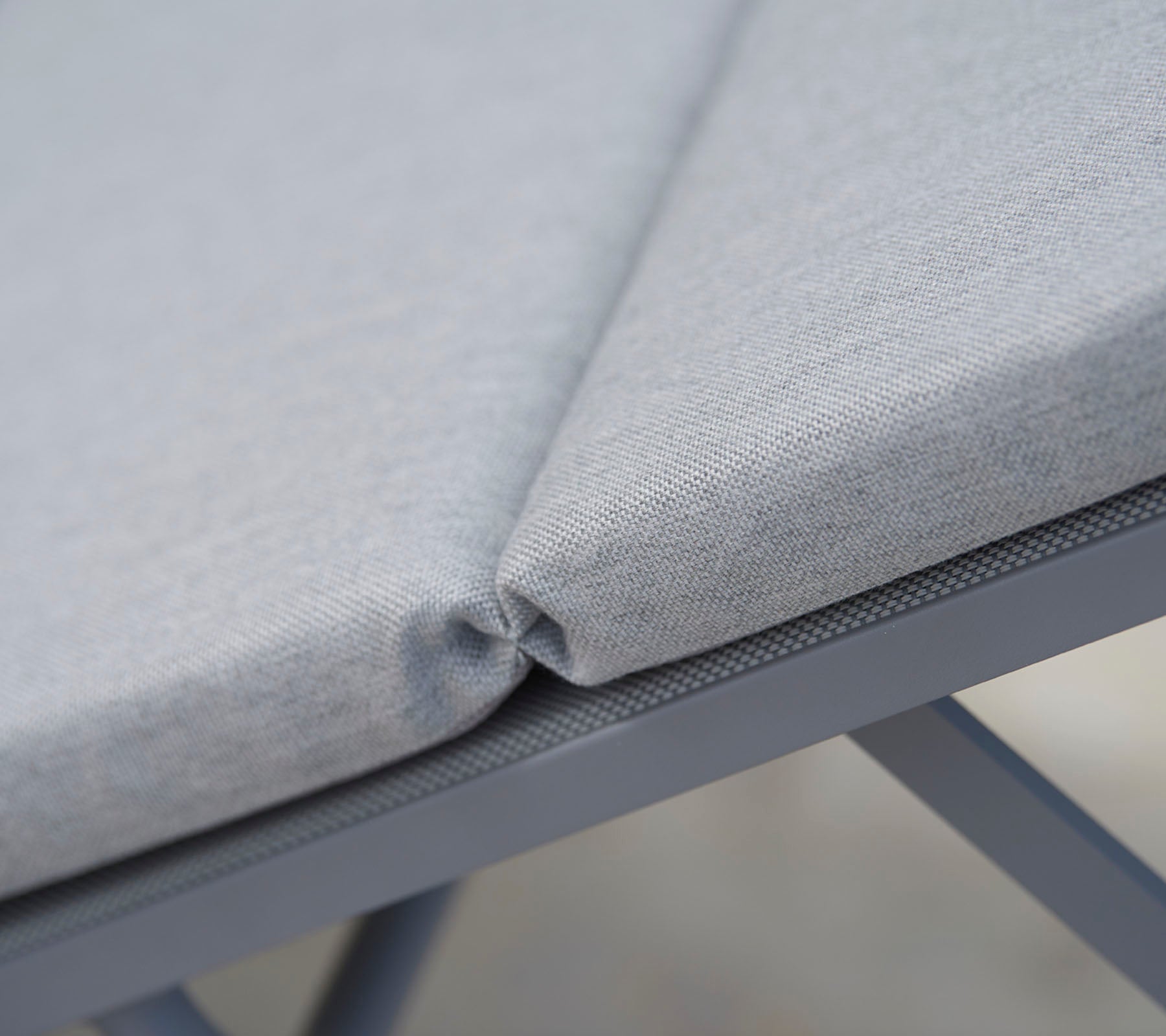 Tejido de asiento gris acolchado con costuras limpias, que muestra un diseño sin costuras y una estructura de soporte duradera.
