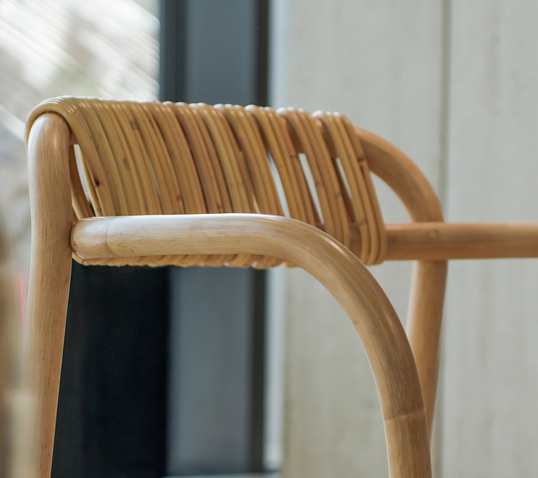 Acercamiento de una silla de bambú moderna con un respaldo tejido único.