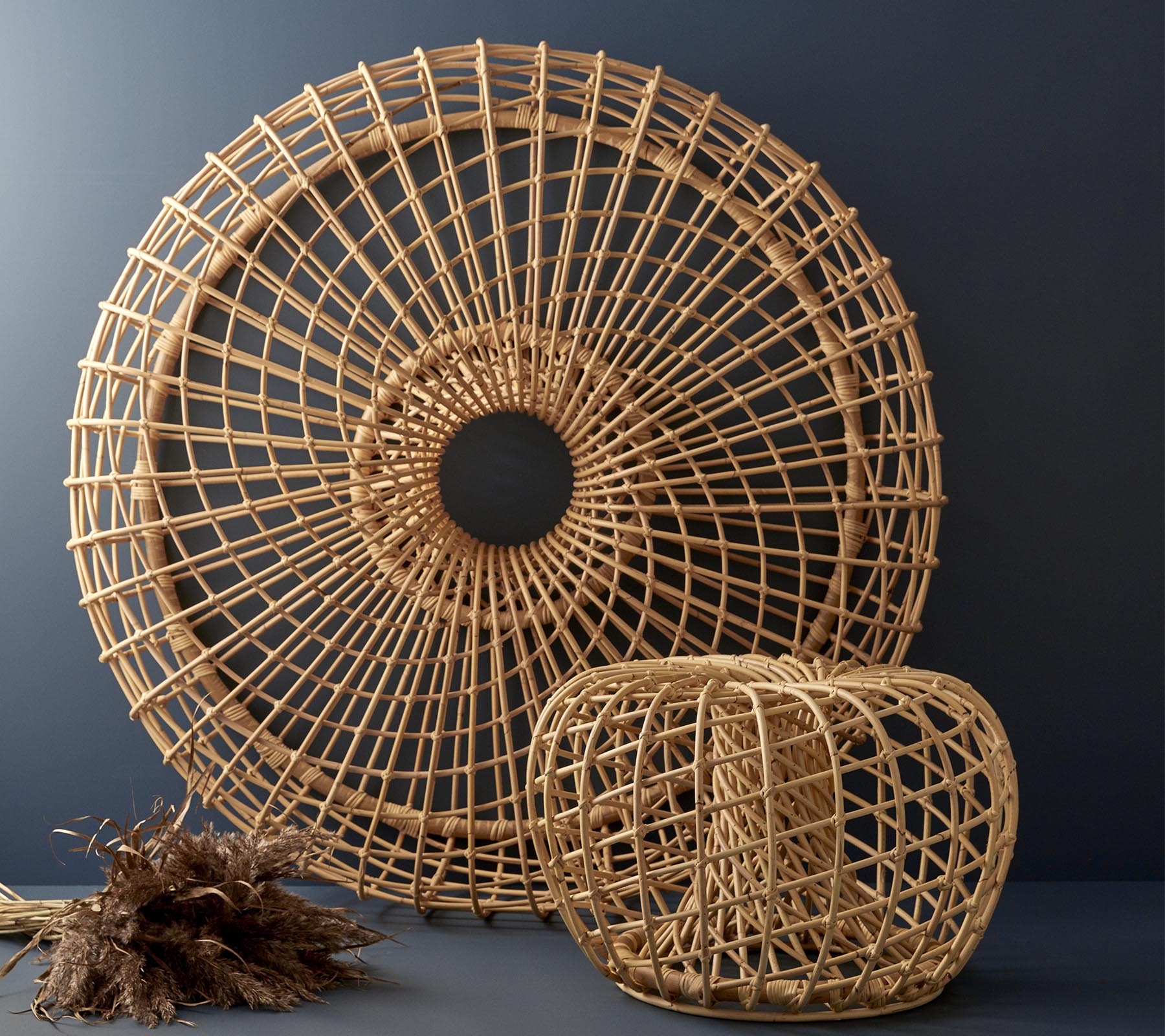 Piezas decorativas de ratán tejidas en forma circular y diseño cúbico, que exhiben patrones intrincados y texturas naturales.