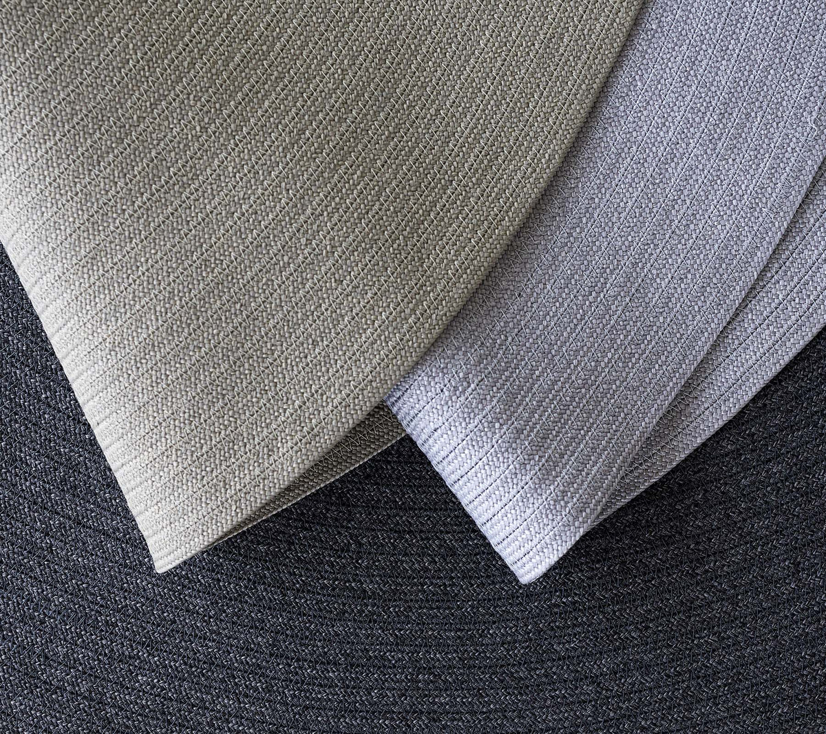 Tres tejidos texturizados superpuestos en varias sombras de gris, mostrando diferentes patrones y tonos para aplicaciones de diseño.