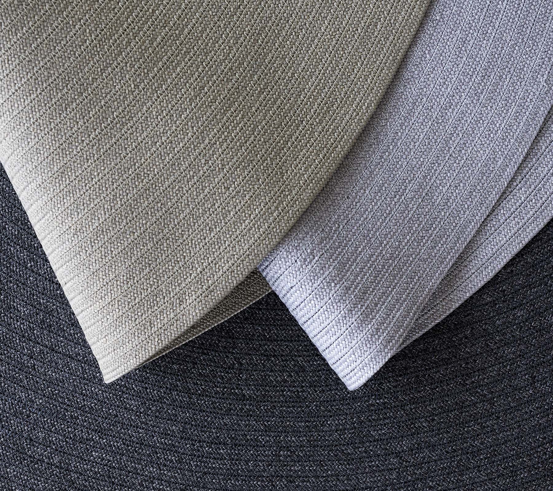 Tres tejidos texturizados superpuestos en varias sombras de gris, mostrando diferentes patrones y tonos para aplicaciones de diseño.