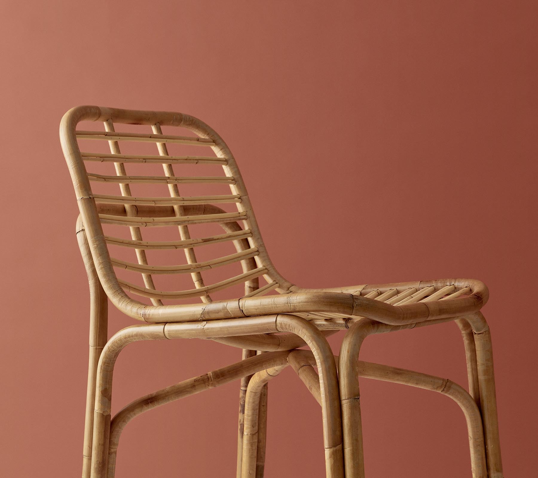 Silla tejida elegante con un acabado natural, que presenta un diseño minimalista sobre un fondo sutil.