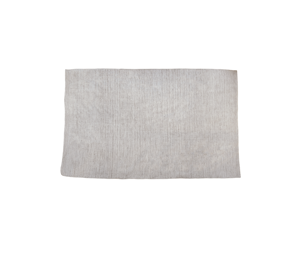 Alfombra multicolor en tono arena con superficie texturizada.