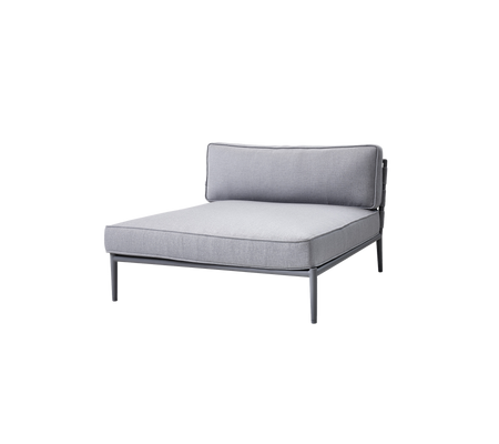 Sillón lounge gris tapizado con un diseño minimalista y un marco de metal elegante, con un respaldo y un área de asientos espaciosa.