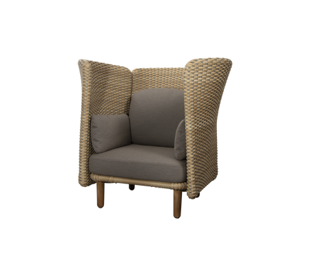Sillón elegante con un diseño tejido y suaves cojines grises, con laterales altos que aportan comodidad y privacidad.